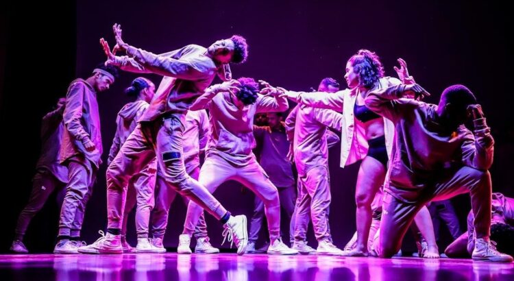 Hiphopdansers voeren een expressieve choreografie uit op een verlicht podium