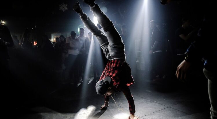 Krumpdanser voert een krachtige handstand uit in een donkere club